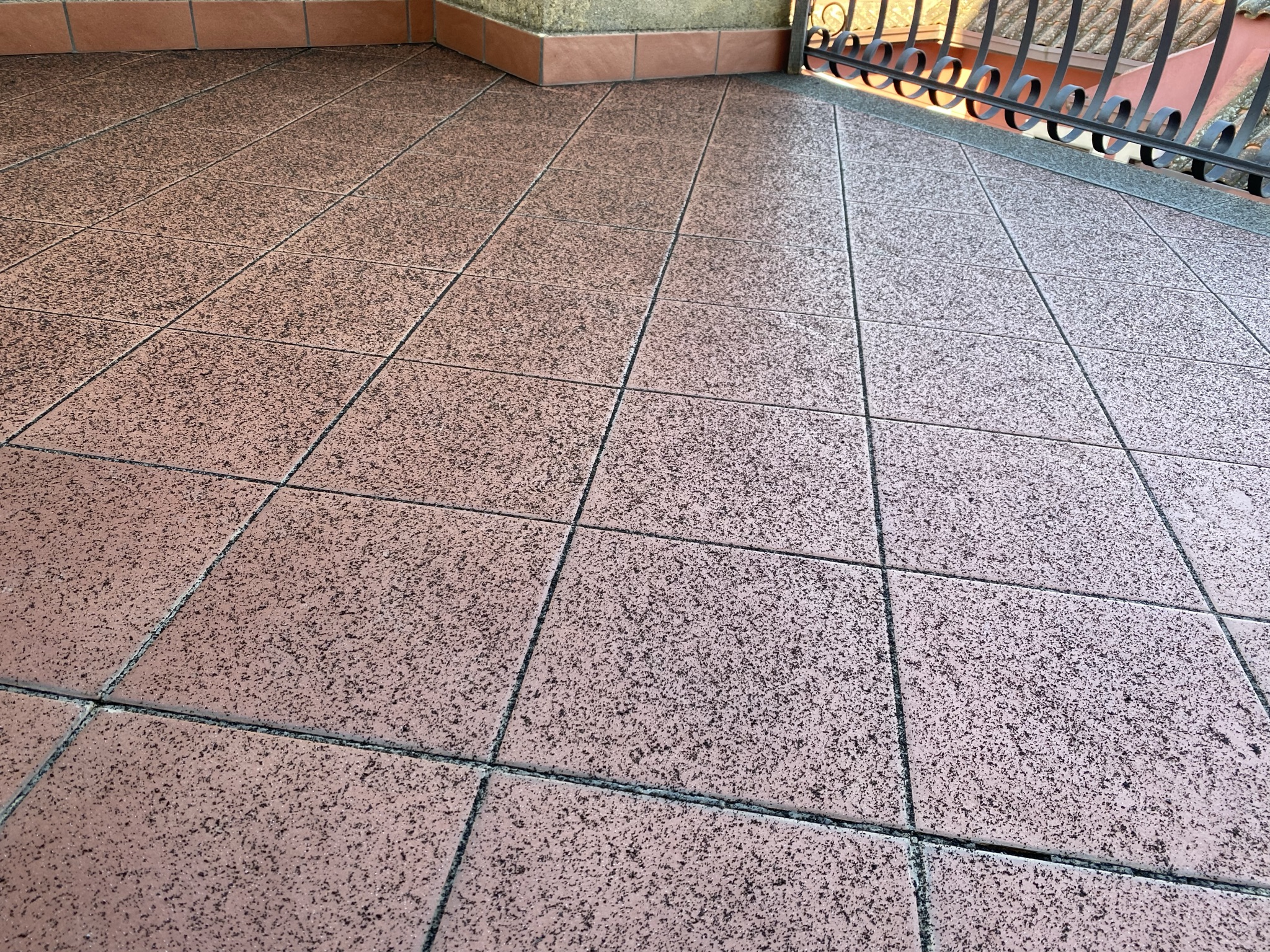 Pink granite terrace tiles with iron railing, typical of Etna region volcanic stone architecture