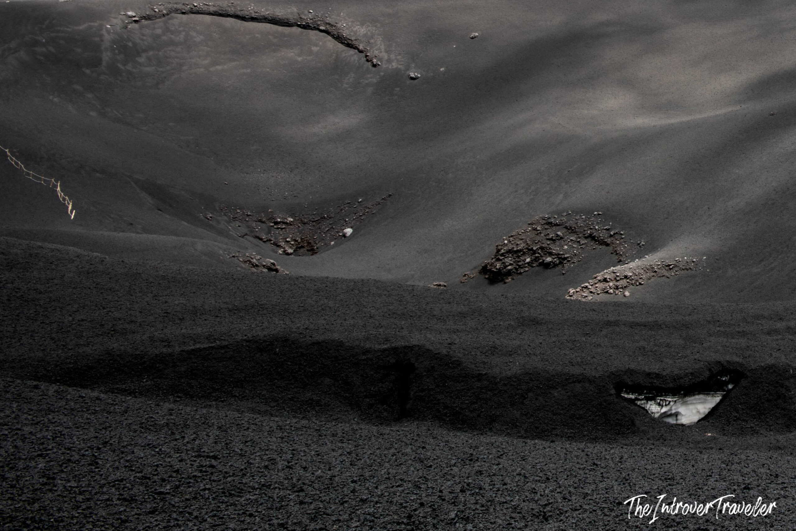 Dark volcanic ash and lava rock terrain on Mount Etna's crater slopes, Sicily
