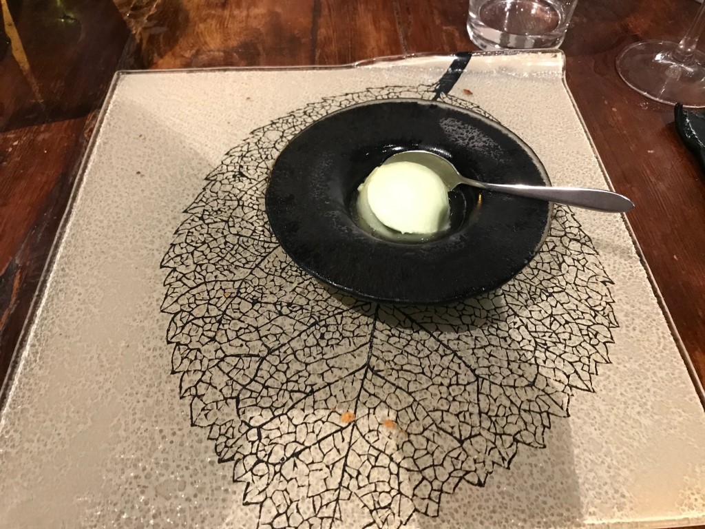 Pale green sorbet in a dark bowl at Osteria I'Ciocio, served on a leaf-patterned placemat