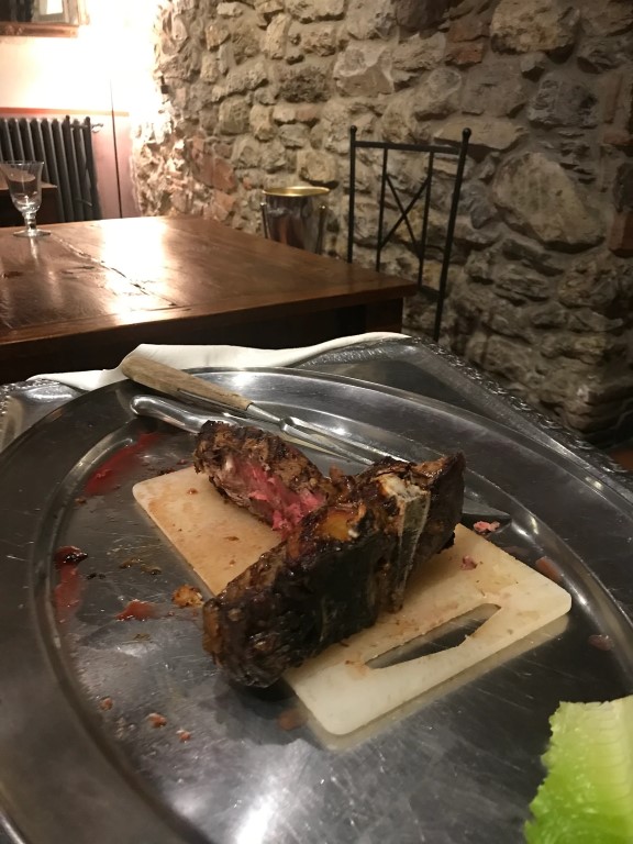Sliced bistecca served on a cutting board at Osteria I'Ciocio, Suvereto, Tuscany