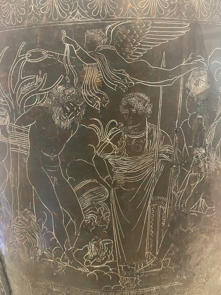 Close-up of engraved mythological scene on an Etruscan bronze vessel at Villa Giulia Museum, Rome