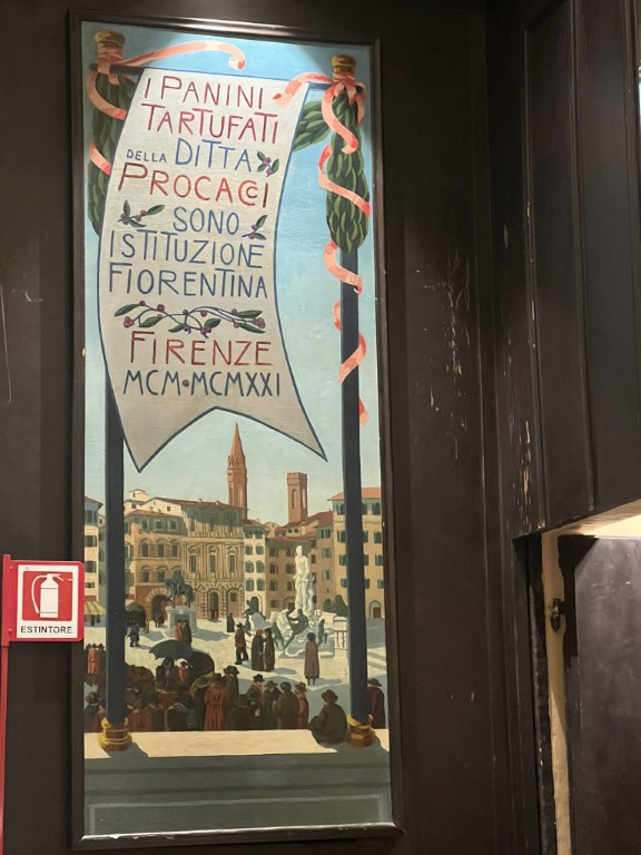 Vintage painted sign at Procacci 1885 declaring panini tartufati a Florentine institution since 1921