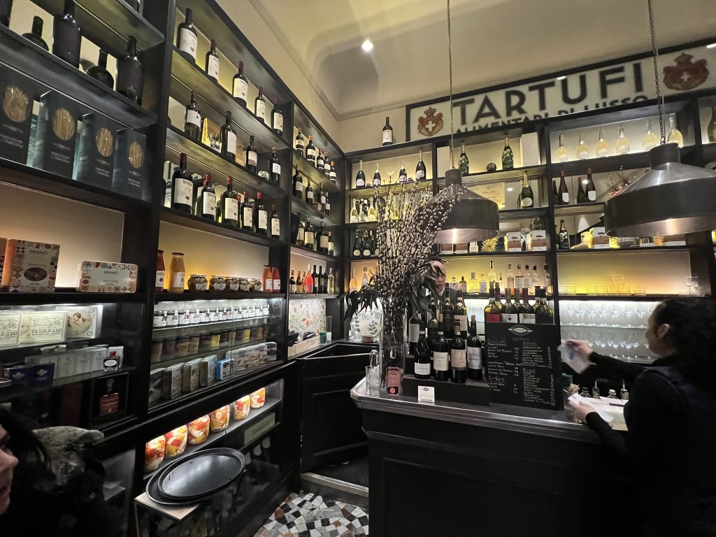 Interior of Procacci 1885 Florence, showing wine shelves and the Tartufi luxury food sign