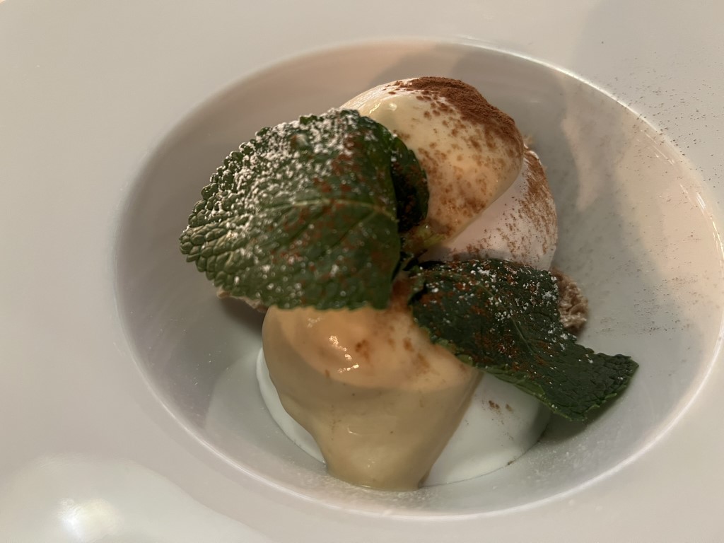 Tiramisu dessert at Parlor Bologna, dusted with cocoa and garnished with mint leaves