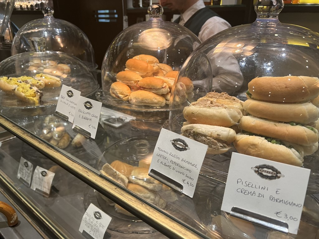 Procacci 1885 display case with tramezzini and rolls including pisellini e crema di parmigiano