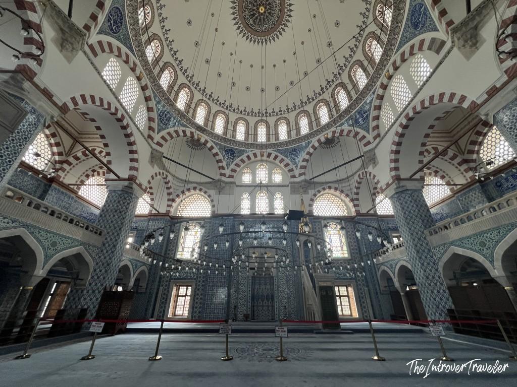 Interior of Rustem Pasha Mosque, Istanbul, showcasing Iznik tile walls and soaring domed ceiling