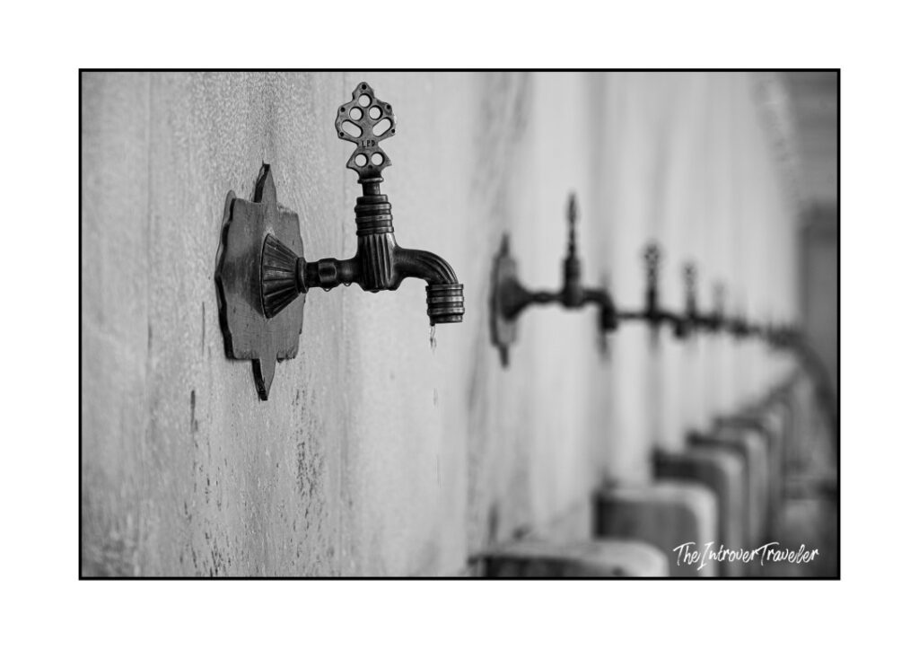 Row of ornate Ottoman-style brass taps at a Turkish mosque ablution fountain in Istanbul