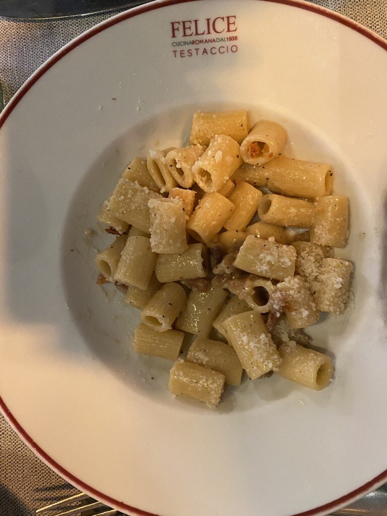 Rigatoni cacio e pepe served on a branded plate at Felice a Testaccio, Rome