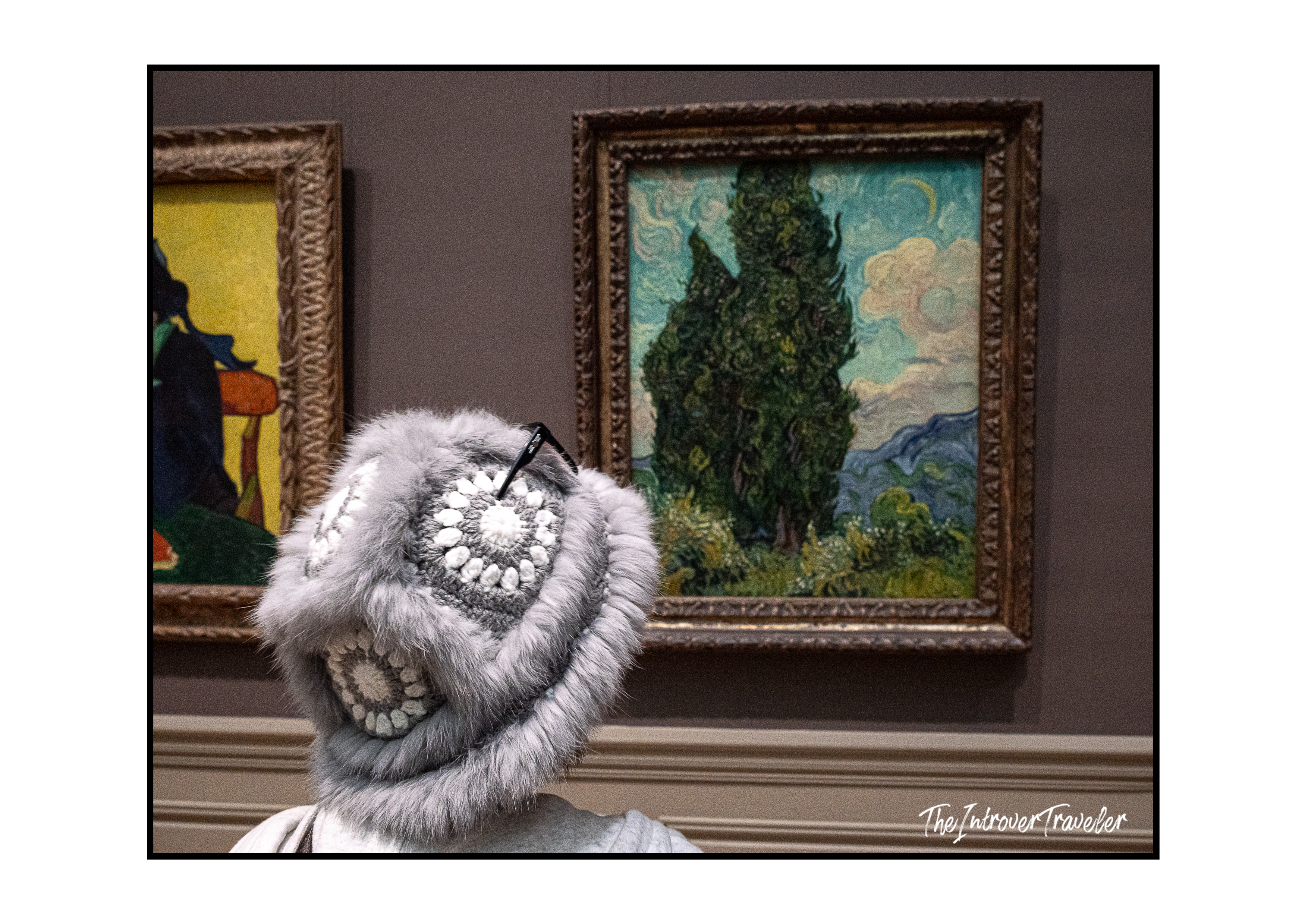 Visitor in a fur hat admiring Van Gogh's Cypresses painting at the Metropolitan Museum of Art