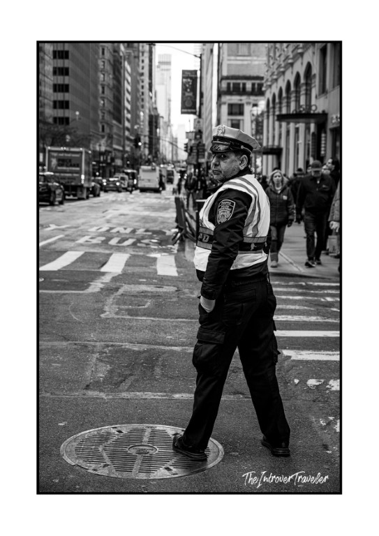 NYPD traffic officer directing traffic on a busy Manhattan intersection, black and white street photography