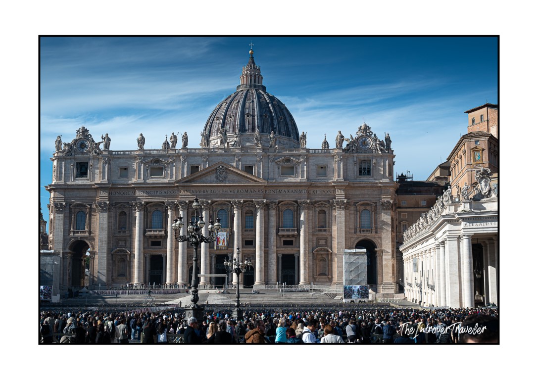 St. Peter's Basilica facade and dome towering over a packed crowd in St. Peter's Square during the Angelus