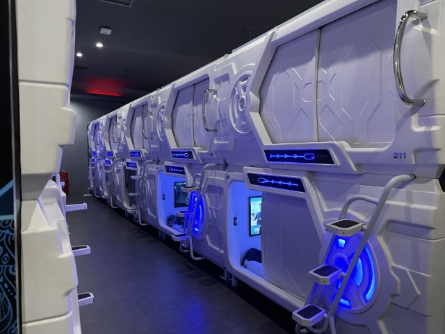 Row of futuristic white airport capsule pods with blue LED lighting at Jakarta airport