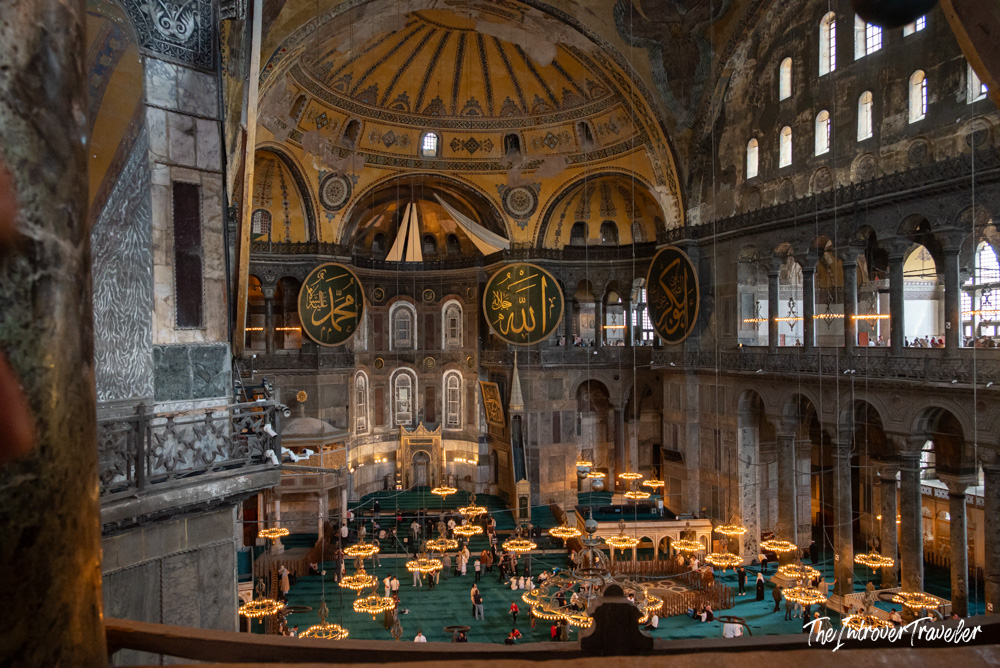 Hagia Sophia interior, Istanbul, showing vast domed nave, Islamic calligraphy medallions, and chandelier-lit prayer hall