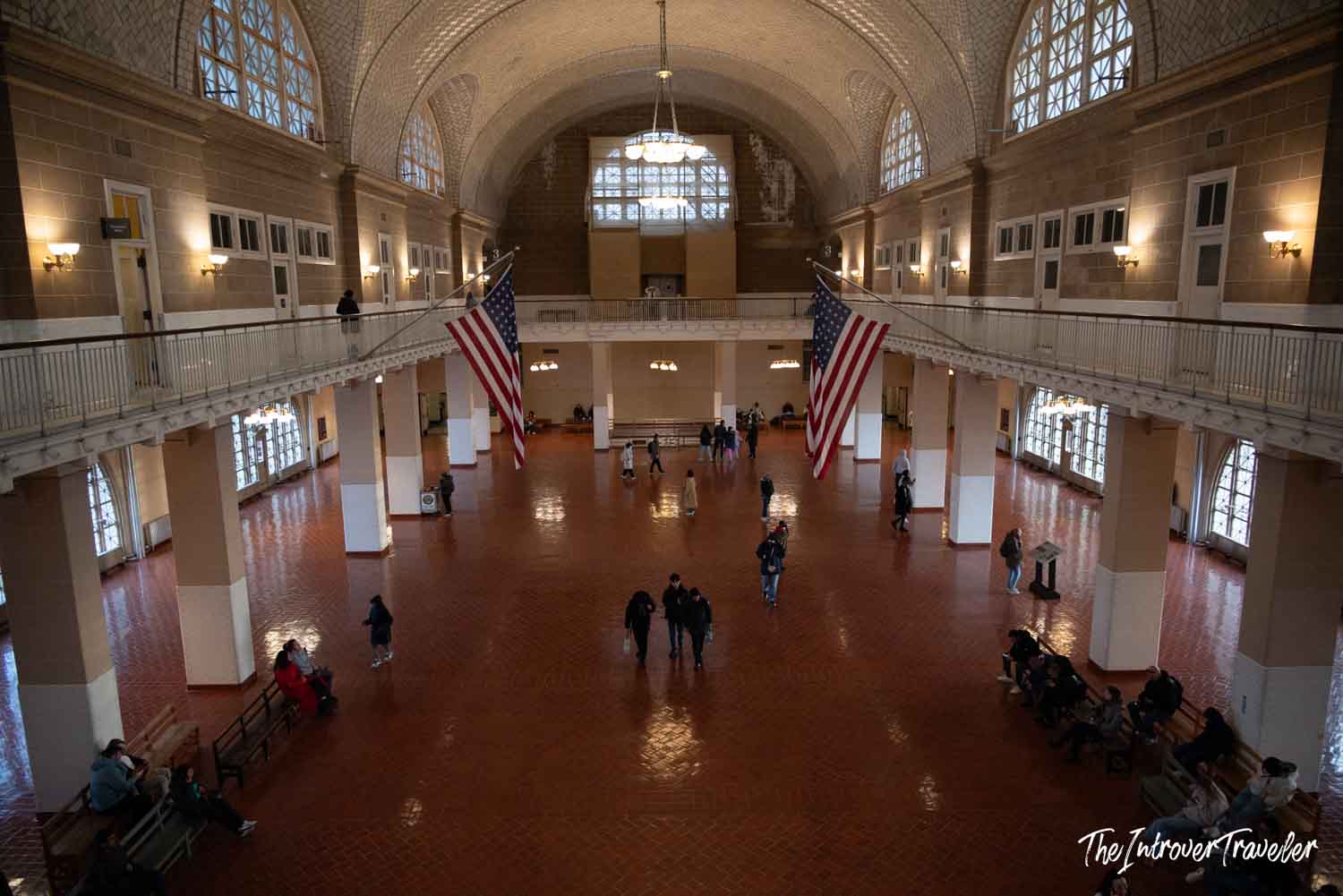 Ellis Island Immigration Museum Registry Room with two large US flags and vaulted tiled ceiling