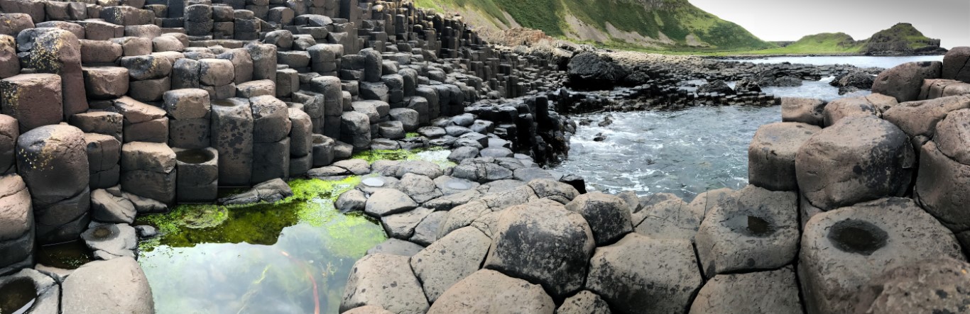 Giant's Causeway hexagonal basalt columns with tidal pools and green cliffs, County Antrim, Northern Ireland