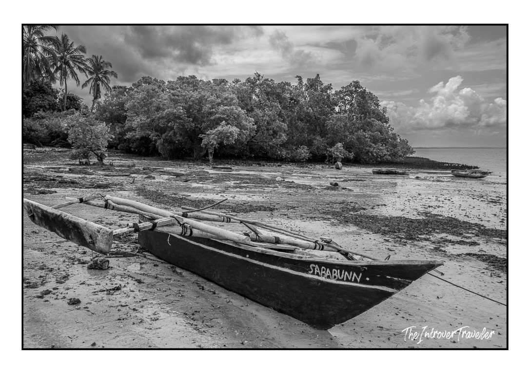 Traditional outrigger canoe named Sarabunn beached at low tide on Mafia Island, Tanzania