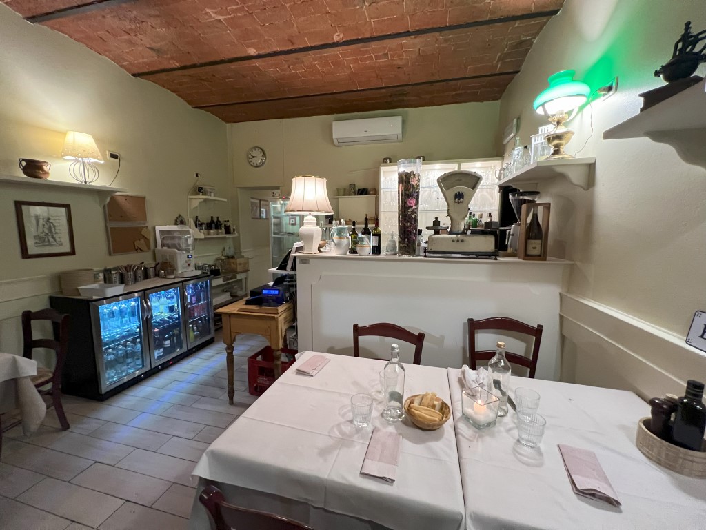 Cozy dining room at Trattoria Casa Mia in Bologna, with brick ceiling and set tables