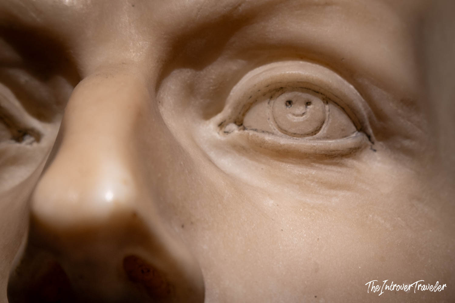 Close-up of a marble bust eye by Algardi featuring his signature smiley detail carved into the iris
