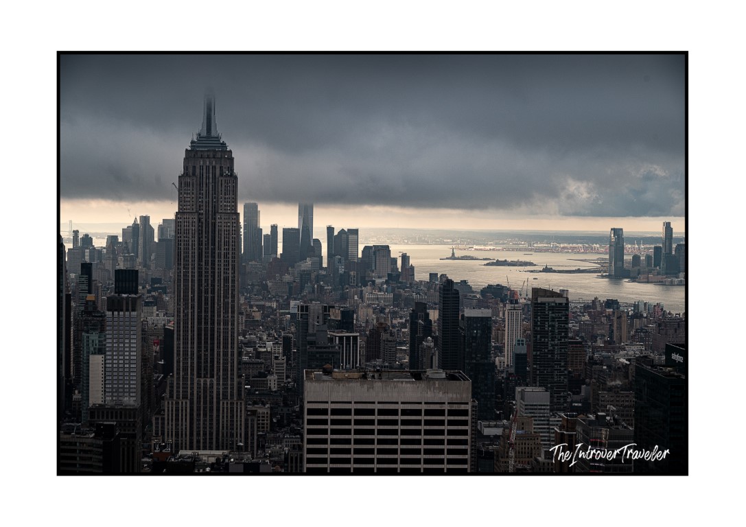 Empire State Building towering over Manhattan skyline under stormy December skies, New York