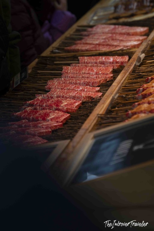 Rows of marbled wagyu beef skewers on display at a Tsukiji market street food stall, Tokyo