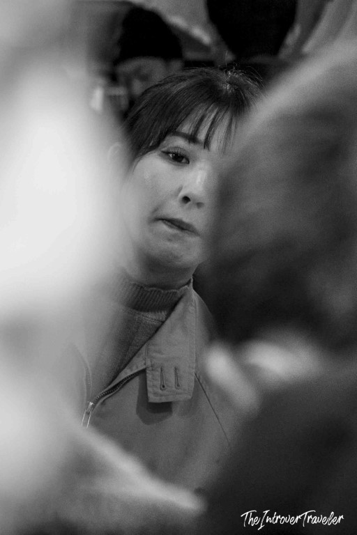 Black and white portrait of a woman amid the busy crowds at Tsukiji fish market, Tokyo