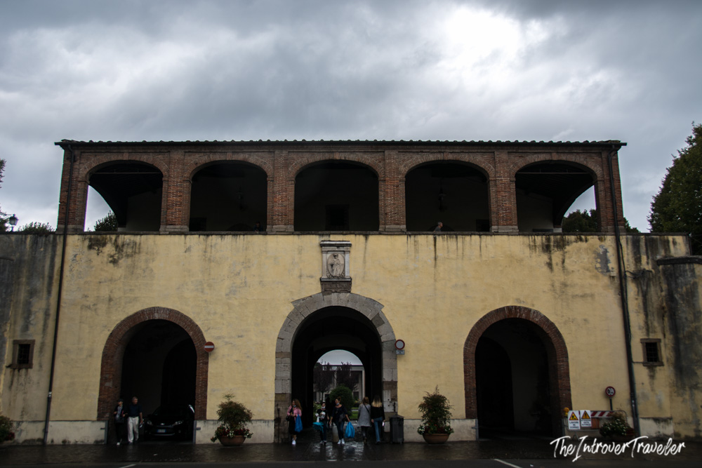 Arched gateway through Lucca's historic city walls, leading into the old town center