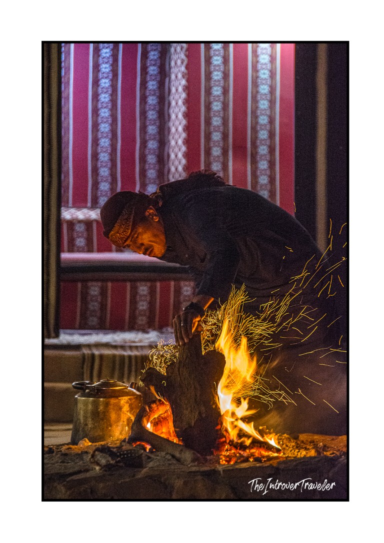Bedouin man tending an open fire inside a traditional Wadi Rum desert camp in Jordan