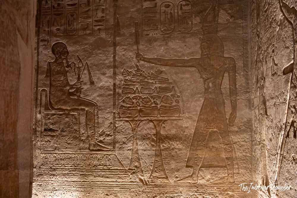 Ancient Egyptian relief carvings inside Abu Simbel temple, showing an offering scene with hieroglyphs