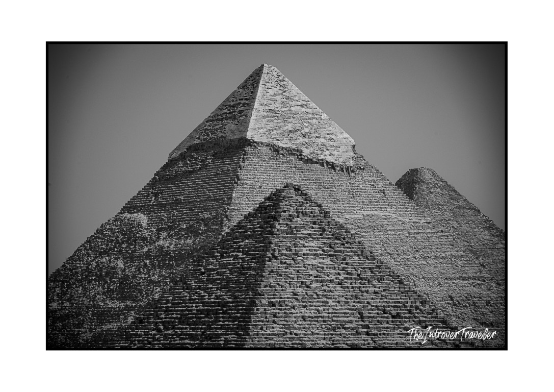 Black and white close-up of the Pyramid of Khafre at Giza, with smaller pyramids visible behind it