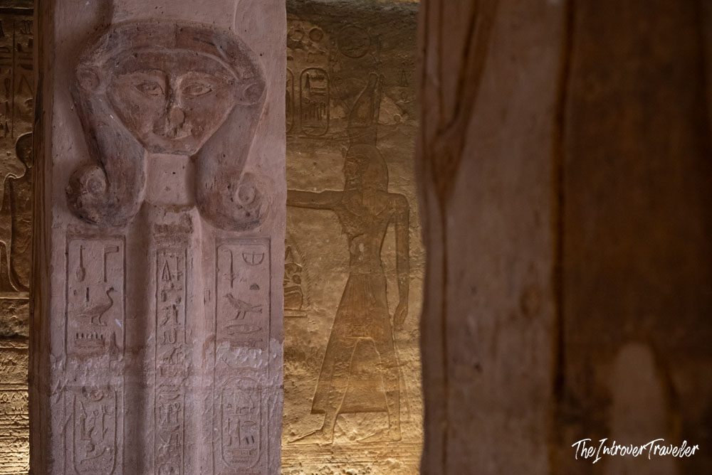 Hathor-headed pillar with hieroglyphs and carved deity relief inside Abu Simbel temple, Egypt
