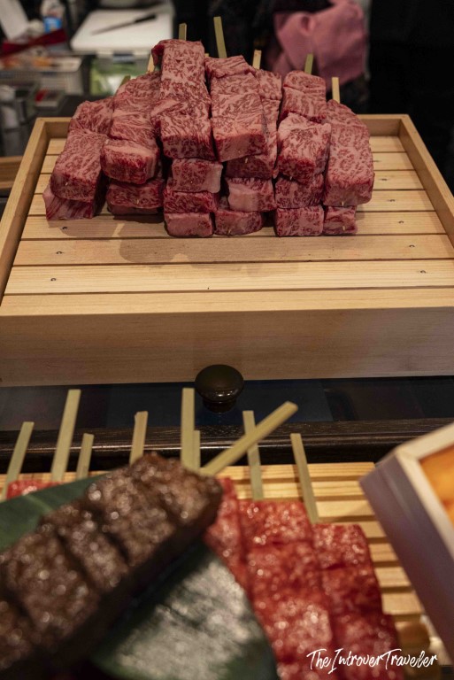 Heavily marbled raw wagyu beef cubes on a wooden tray at Tsukiji market, Tokyo