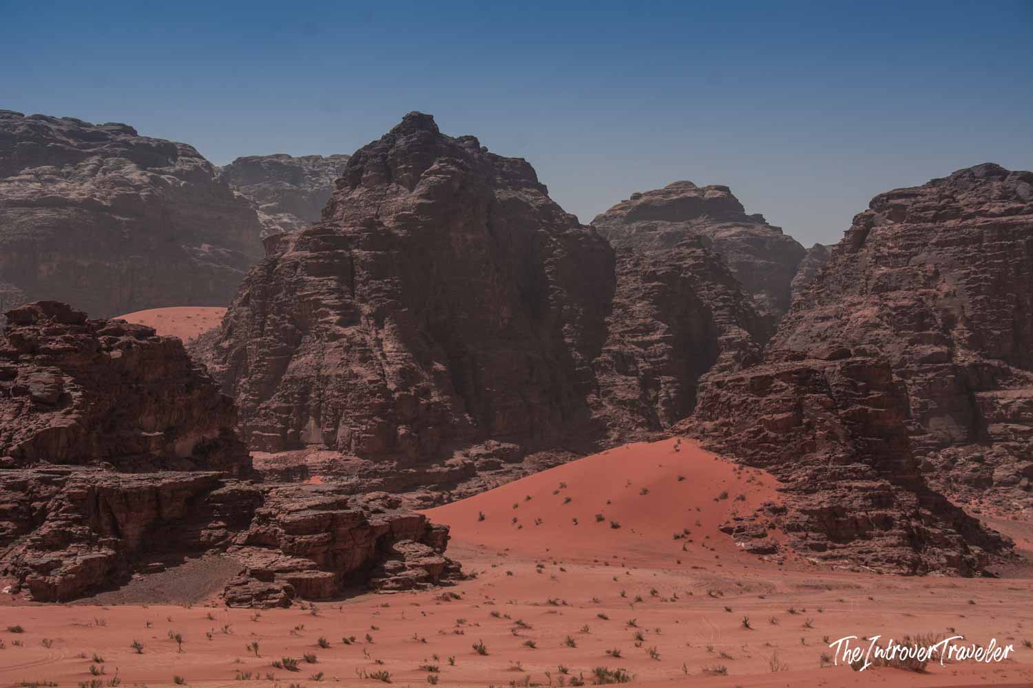 Red sand dunes and towering sandstone cliffs in Wadi Rum desert, Jordan