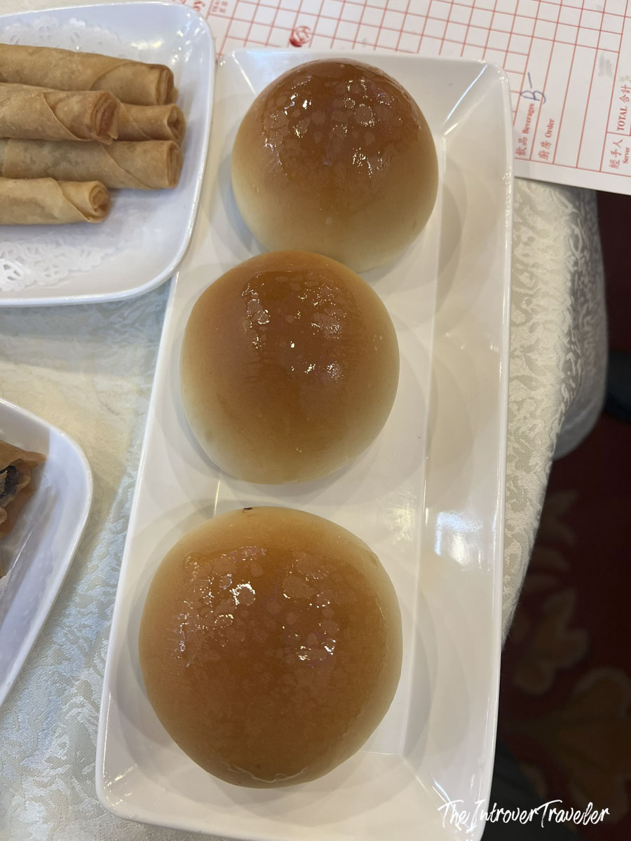 Three glossy baked BBQ pork buns served at House of Joy dim sum restaurant in Chinatown, Manhattan