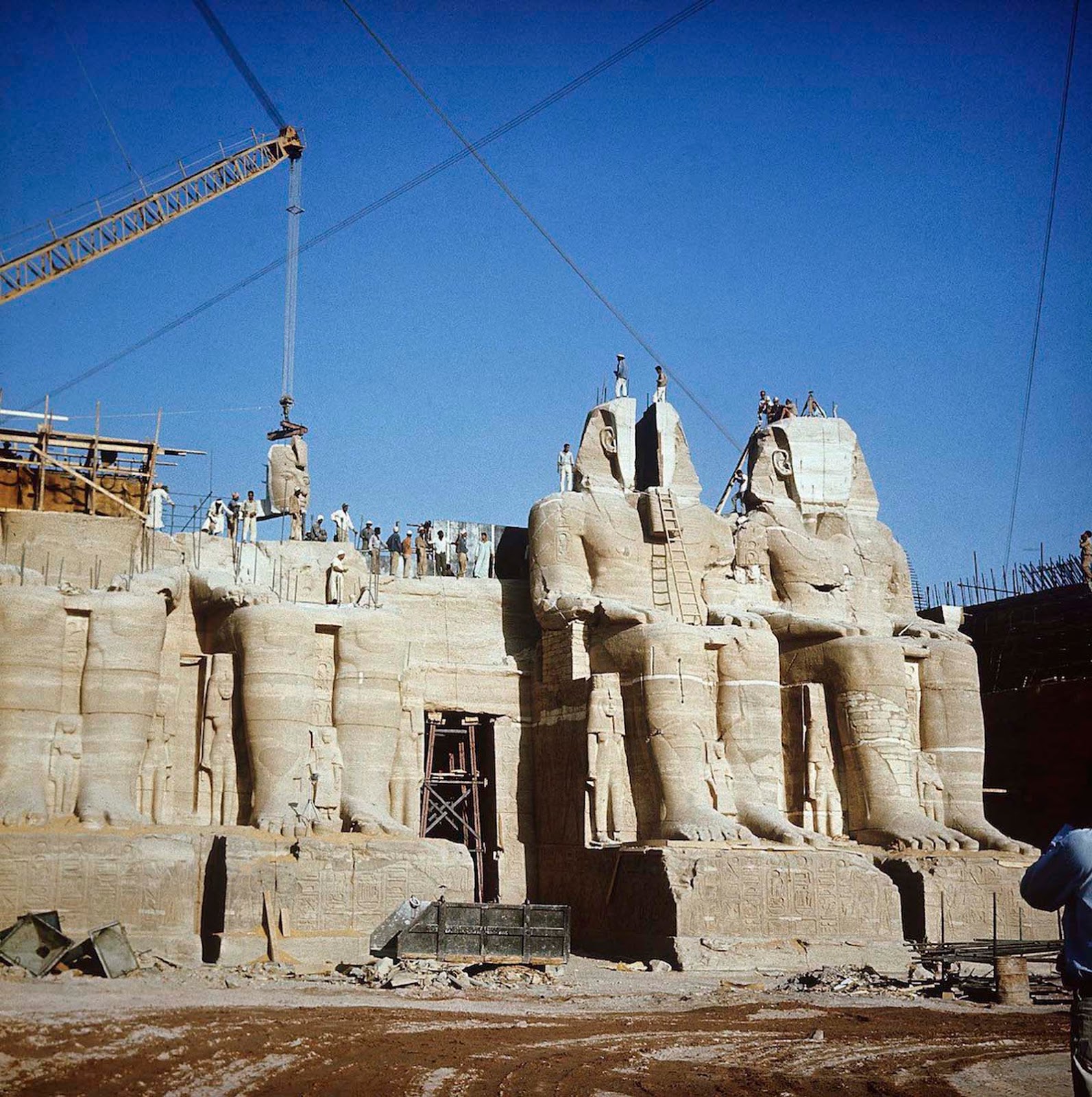 Relocation of Abu Simbel temple facade, with cranes and workers reassembling the colossi of Ramesses II