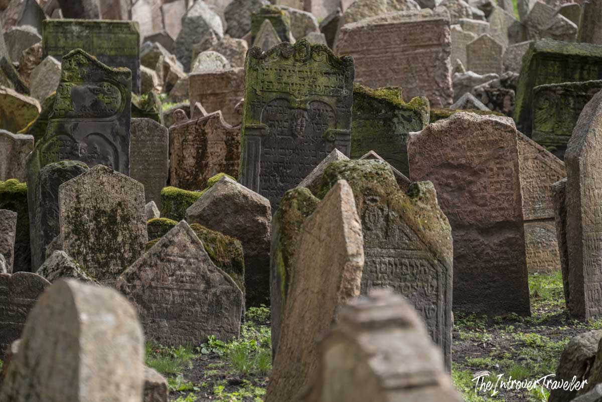 Densely packed moss-covered Hebrew gravestones at the Old Jewish Cemetery in Prague