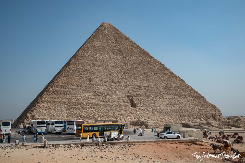 Great Pyramid of Giza with tourist buses, camels, and visitors at the base, Giza Plateau Egypt
