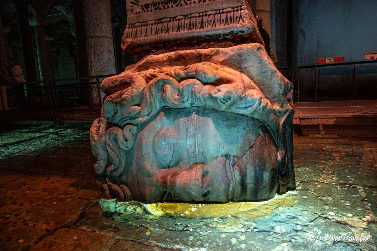 Medusa head column base in the Basilica Cistern, Istanbul, lit by dramatic colored lighting