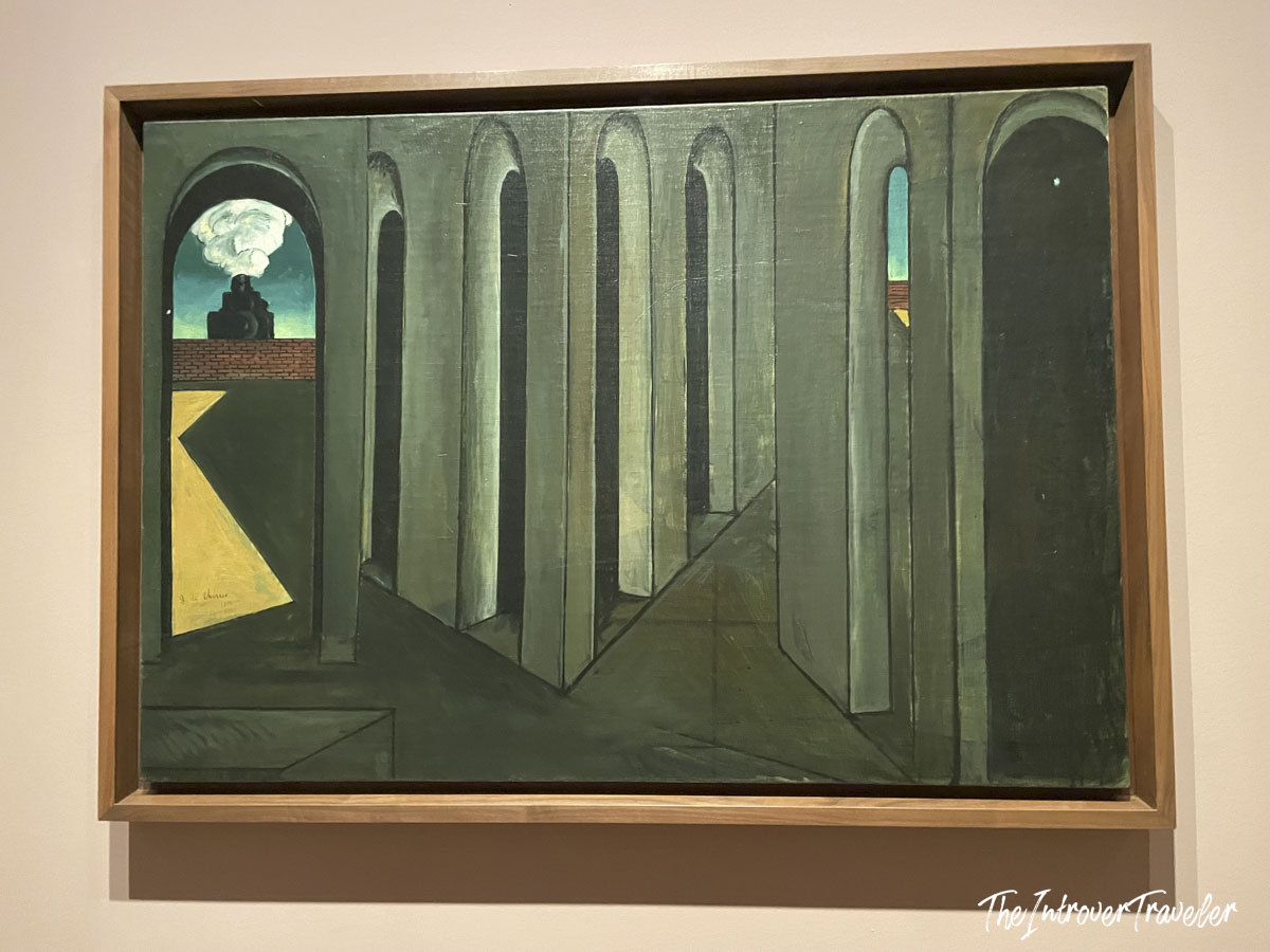 Giorgio de Chirico metaphysical painting with arched arcade and steam train, on display at MoMA New York