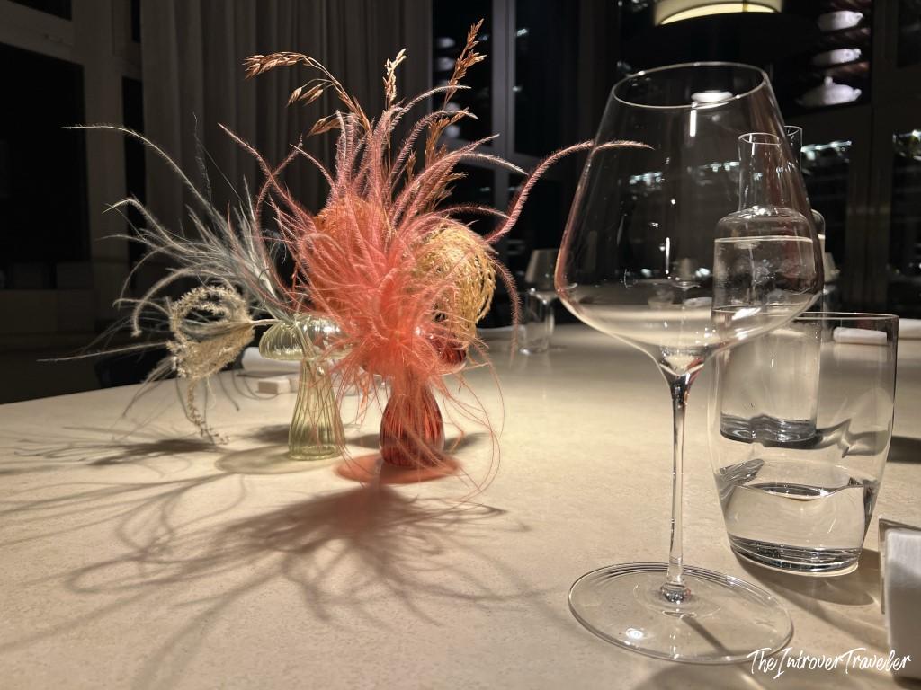 Elegant table setting at a fine dining seafood restaurant in Rimini, with dried grass centerpiece and wine glasses