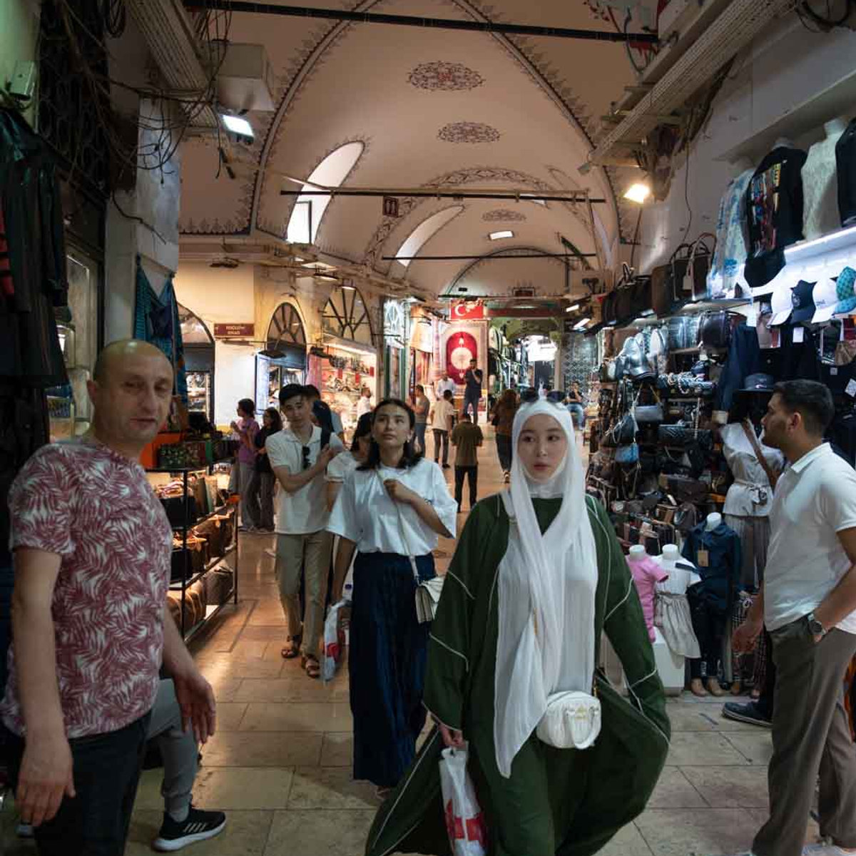 Shoppers walking through a busy vaulted corridor inside Istanbul's Grand Bazaar