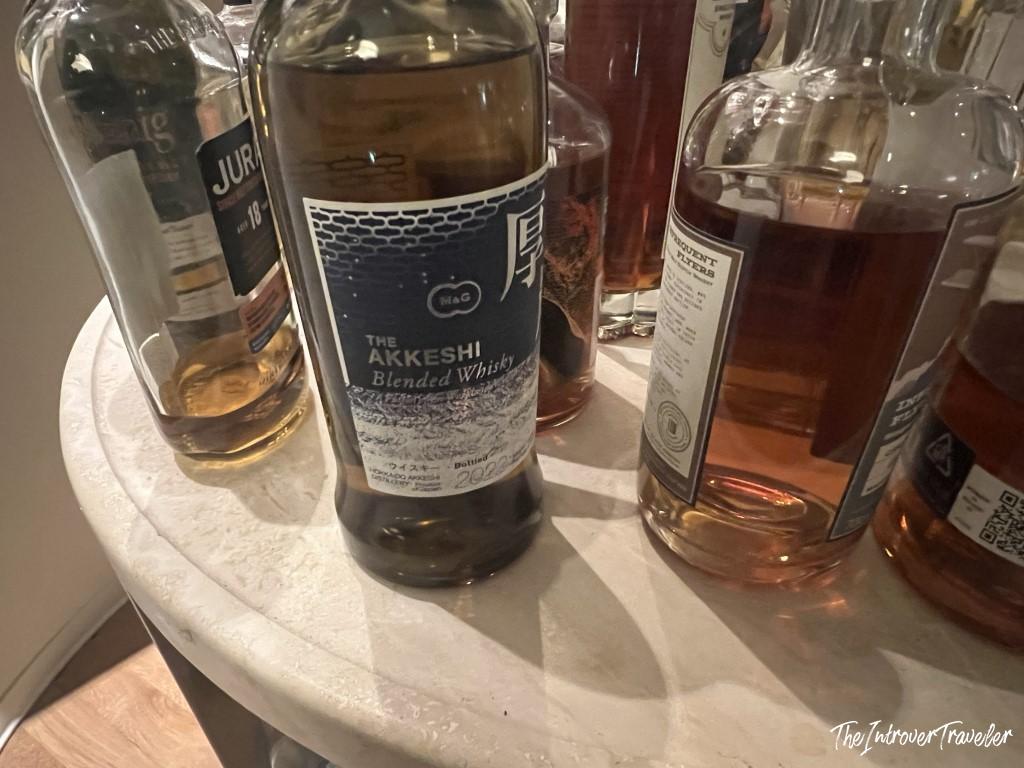 Akkeshi Blended Whisky bottle on a marble table beside Jura 18 and other whiskies