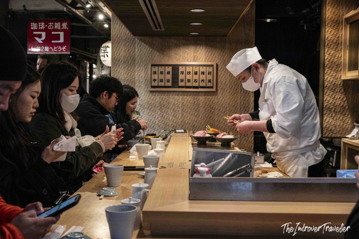 Chef preparing fresh seafood at a counter restaurant inside Tsukiji fish market, Tokyo