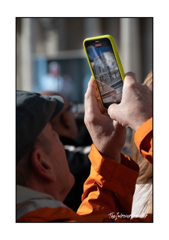 Tourist photographing St. Peter's Square on a smartphone during the Pope's Angelus in Rome