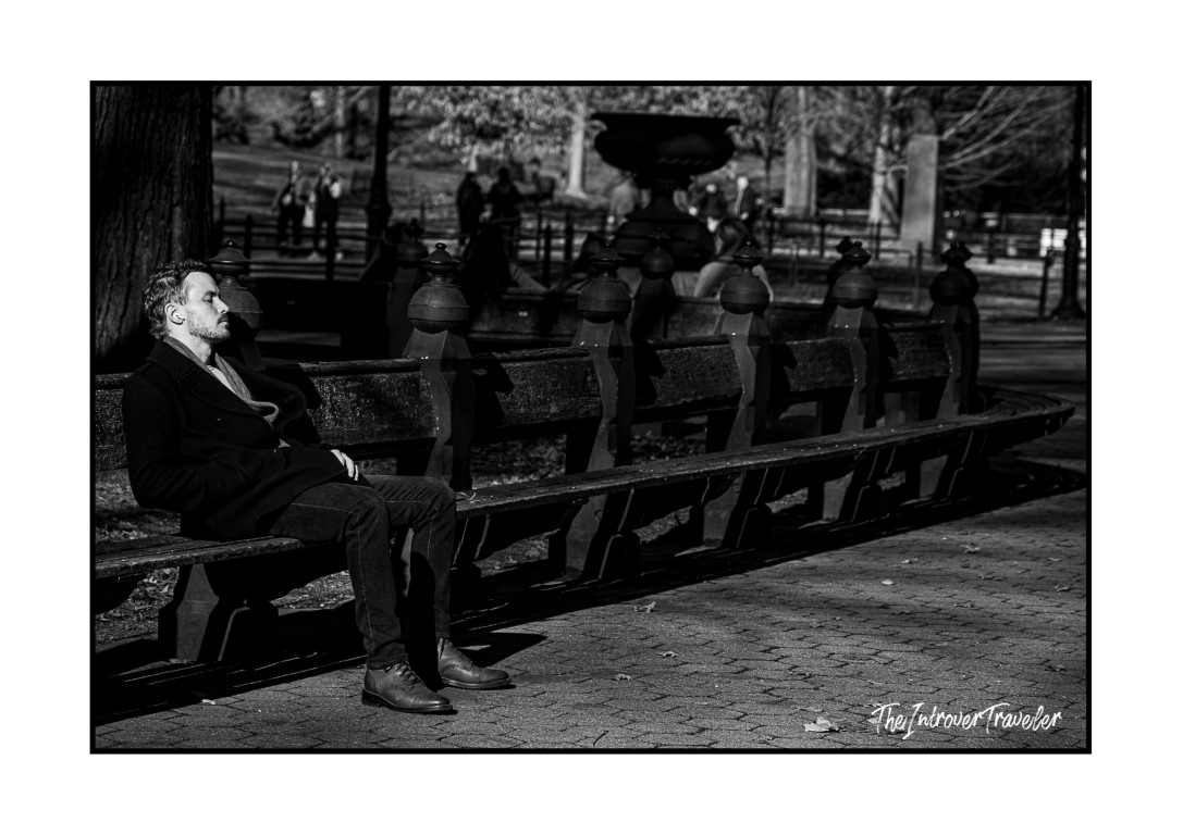 Man resting on a park bench near Bethesda Fountain, Central Park, New York City