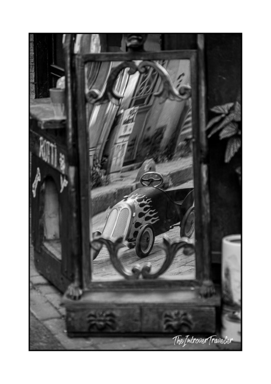 Vintage toy race car with flame details reflected in an ornate antique mirror, Istanbul street market