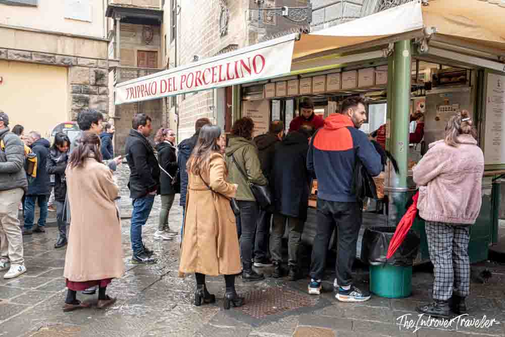 Crowd of locals and tourists queuing at Trippaio del Porcellino street food stall in Florence