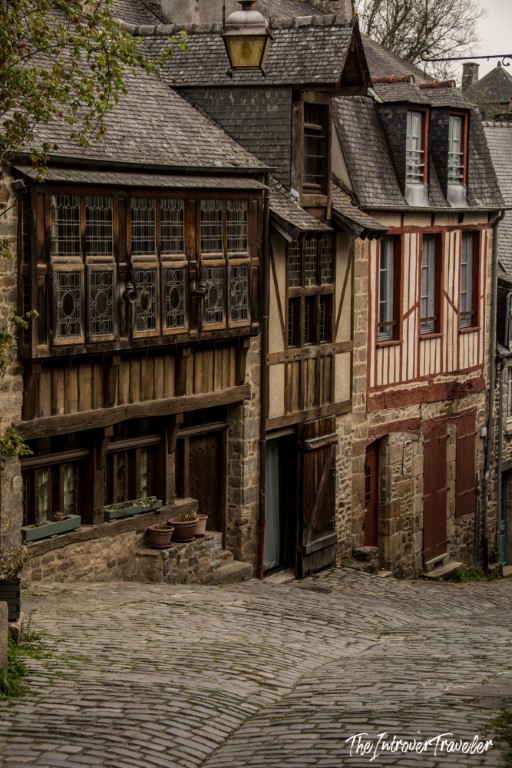 Cobblestone street lined with medieval half-timbered houses in Dinan, Brittany, France