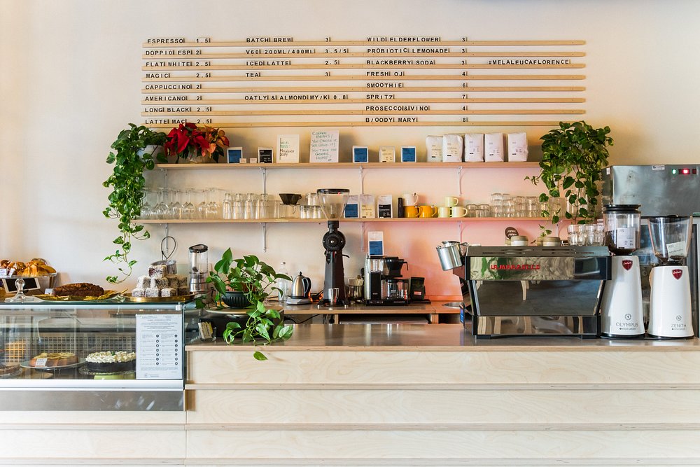 Melaleuca Florence coffee bar with espresso machine, wooden menu board, and pastry display case