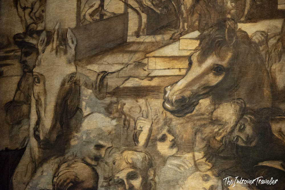 Close-up detail of a dramatic painting at the Uffizi Gallery, showing horses and figures in sepia tones