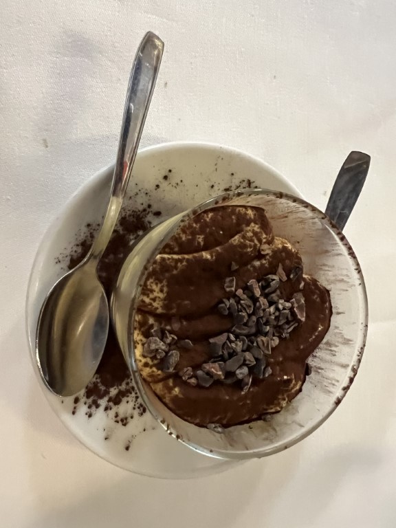 Tiramisu dessert at Le Antiche Carampane, topped with cocoa powder and chocolate nibs